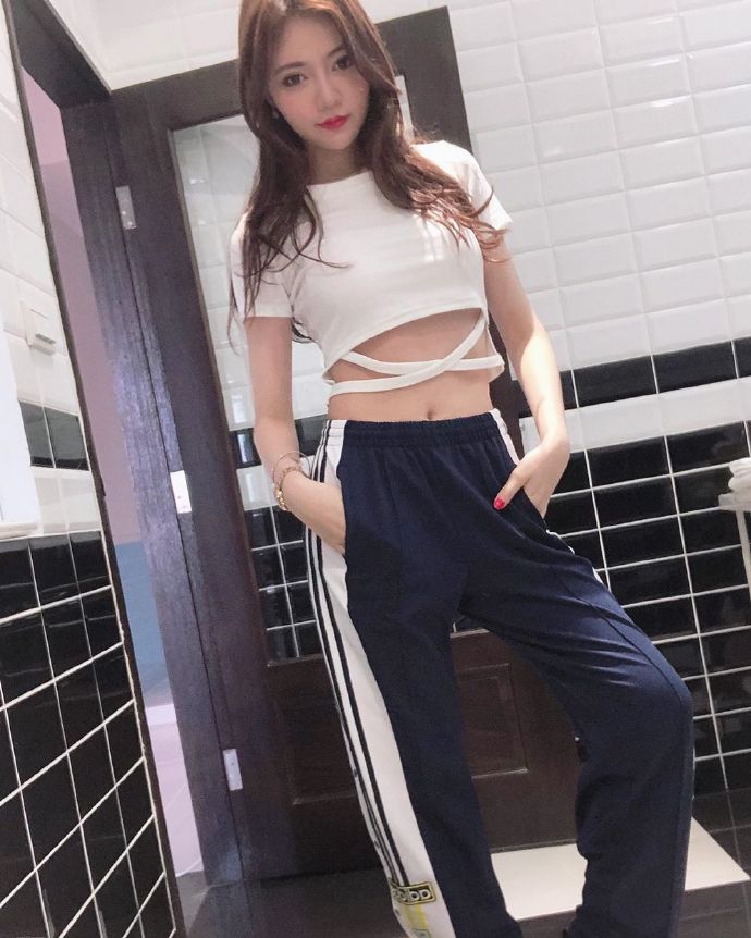 运动美女紧身白T搭配运动长裤露美腿图片 4